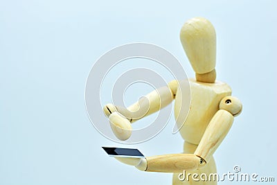 Wooden mannequin with a mobile in hand Stock Photo