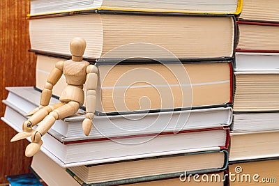 Wooden mannequin sit on the bookshelf Stock Photo