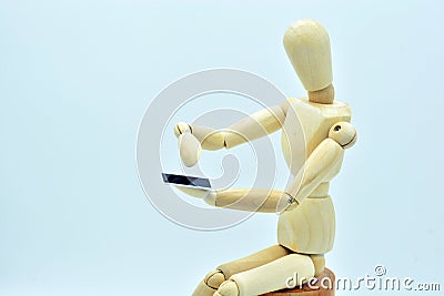 Wooden mannequin with a mobile in hand Stock Photo