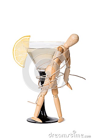 Wooden mannikin strapped to the glass of vermouth. Concept of drunkenness, alcohol abuse Stock Photo