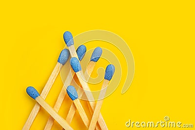 Wooden matches sticks with blue head on a yellow backgroud Stock Photo