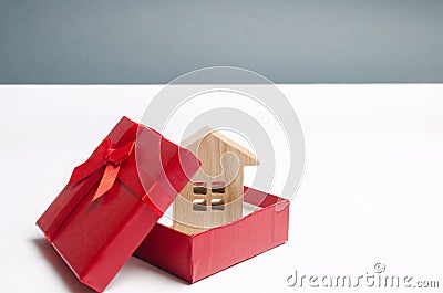 Wooden miniature house in a gift box. Housing as a gift. Win an apartment in the lottery. To inherit property. Holiday discounts. Stock Photo