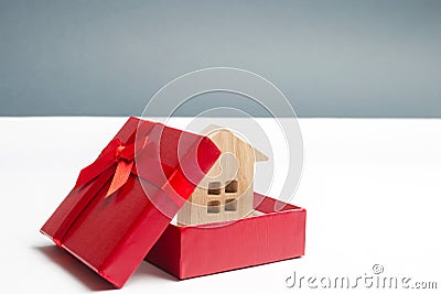 Wooden miniature house in a gift box. Housing as a gift. Win an apartment in the lottery. To inherit property. Holiday discounts. Stock Photo