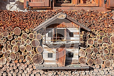 Sauris - Wooden model house covered by sorted firewood in remote alpine village of Sauris di Sotto Stock Photo