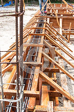 The wooden mold for concrete foundation of a house. The rebar steel for concrete slap and pole. Stock Photo