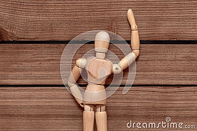 A wooden mvneken peeps into the sheel of a wooden fence, voyeurism. Stock Photo