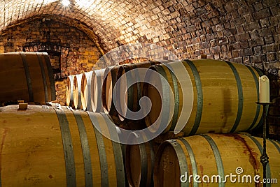 Wooden old barrels in the rustic wine cellar with brick walls in villany hungary Stock Photo