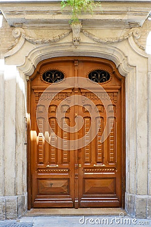 Wooden old-fashioned door of light brown colour at daytime in Zaragoza, Aragon, Spain. Aged elegant entrance. Vintage Spanish Stock Photo