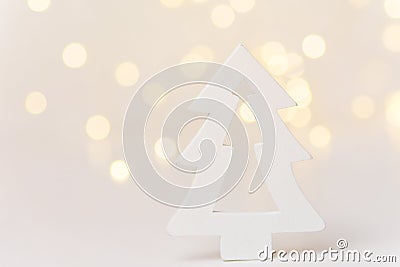 Wooden ornament Christmas tree in forest golden bokeh garland lights white background. New Years holiday magic atmosphere Stock Photo