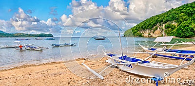 Wooden outriggers on a beach on a tropical island in the Philippines. Editorial Stock Photo