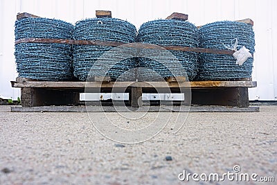 Wooden pallet with spools of barbed wire Stock Photo