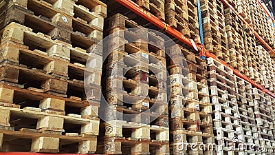 Wooden pallets for product distribution and transportation are stacked in rack of warehouse Stock Photo