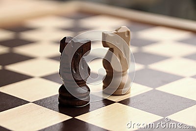 Wooden pieces, chess horses, white and dark brown on a chessboard, game concept Stock Photo