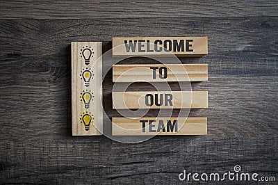 Wooden pieces with light bulbs and message Welcome to our team Stock Photo