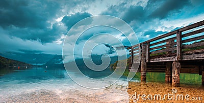 Wooden pier at Bohinj lake on cloudy autumn day Stock Photo