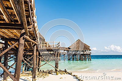 Wooden pier with thatched roof in ocean Stock Photo