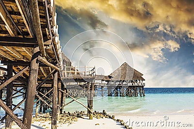 Wooden pier with thatched roof in ocean Stock Photo