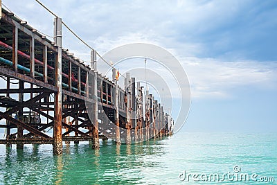 Wooden pier on turquoise water, blue sky, clouds background, ship wharf scenic perspective view seascape, fishing boat dock, quay Stock Photo