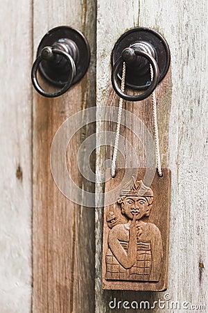 Wooden plate in balinese stile hanging on metal door knob. Don`t disturb sign Stock Photo