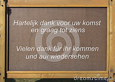 Wooden plate with thank you fror coming in dutch en german Stock Photo