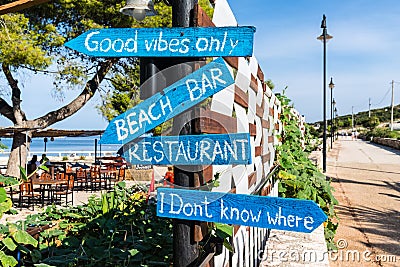 Wooden pointing arrows on the fence. Bar and restaurant on the beach. Ksamil, Albania Editorial Stock Photo