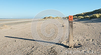 Wooden pole on an empty beach at the North Sea Stock Photo