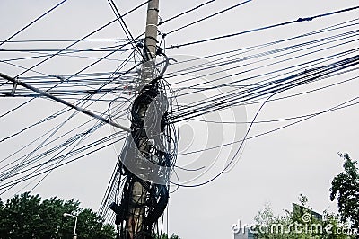 Wooden pole full of phone wires tangled together, telecommunication concept Stock Photo