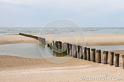 Wooden poles on the beach to break the water Stock Photo