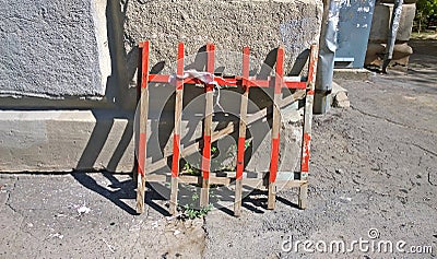 Wooden portable road fence stands against a concrete wall Stock Photo