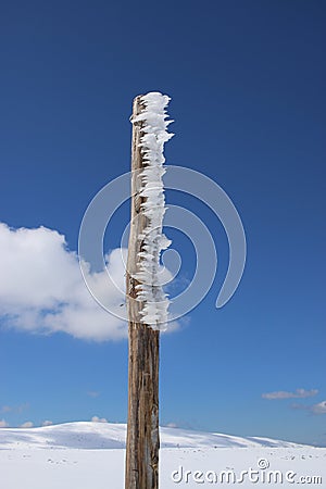 Wooden post chained with ice Stock Photo