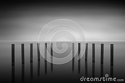 Wooden posts in a lake, long time exposure Stock Photo