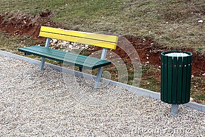 Wooden public bench with same style trash can Stock Photo