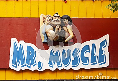 Wooden relief sculpture sign advertising for an arm wrestling machine Mr. Muscle with strong man Editorial Stock Photo