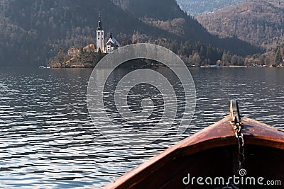 Wooden rent boat, end of the boat facing towards Lake Bled island, focus on Bled island - famous tourist destination in Stock Photo