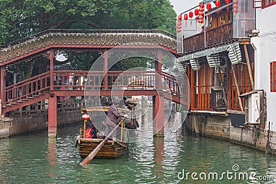 Wooden retro boats move along the houses in ancient town Editorial Stock Photo