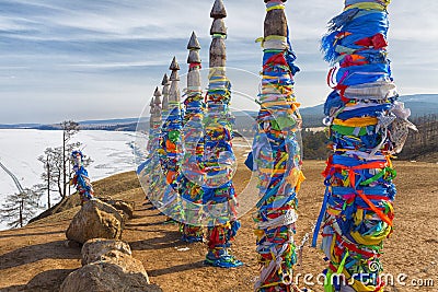 Wooden ritual pillars with colorful ribbons on cape Burkhan, Lake Baikal Stock Photo