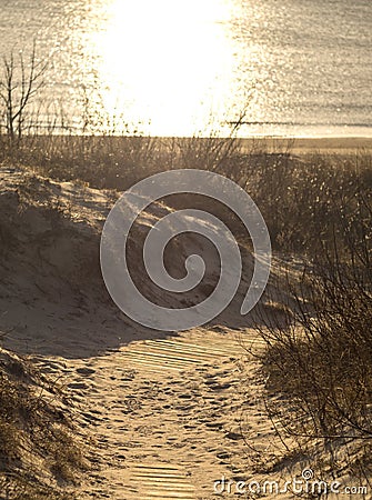 A wooden road among the dunes leading to the Baltic Sea at sunset in Klaipeda, Lithuania Stock Photo