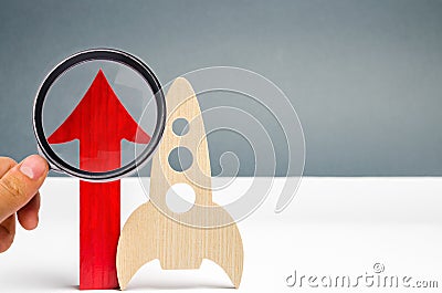 Wooden rocket and up arrow. The concept of a startup. The concept of raising fund for a startup. Charitable contributions to Stock Photo