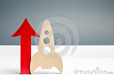 Wooden rocket and up arrow. The concept of a startup. The concept of raising fund for a startup. Charitable contributions to Stock Photo