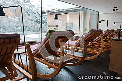 Wooden rocking lounge chairs face snowy mountain view Editorial Stock Photo