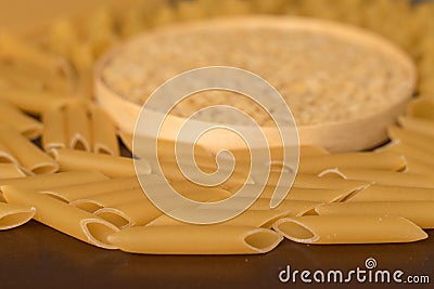 wooden round cup in the middle of italian pasta pepe rigate, snails and penne, feathers Stock Photo