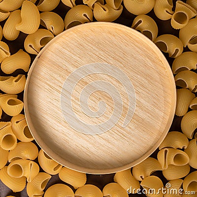 wooden round cup in the middle of italian pasta pepe rigate, snails Stock Photo