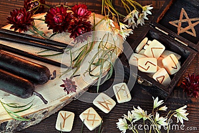 Wooden runes and black candles on witch table Stock Photo