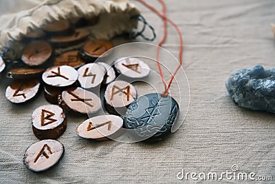 Wooden runes in a canvas bag with a stone runescript Stock Photo