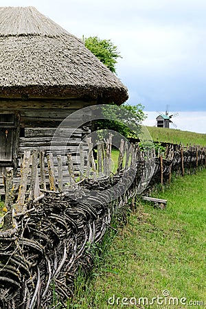 Wooden rural fence in village near the house near the forest. Authentic traditional culture in architecture and life. Sunlight, Stock Photo