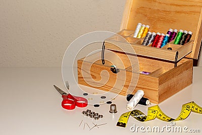 A wooden sewing kit on a white table with many accessories. Perfect for haberdashery Stock Photo