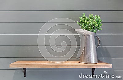 Wooden shelf on plank wall with vase of plastic flower Stock Photo