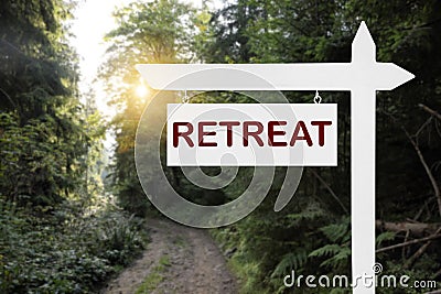 Wooden sign with word Retreat and picturesque view of beautiful forest with path Stock Photo