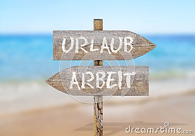 Wooden sign words Arbeit and Urlaub, translation: Work and Vacation Stock Photo