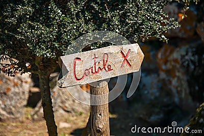 Wooden signboard against tree and rock background Stock Photo